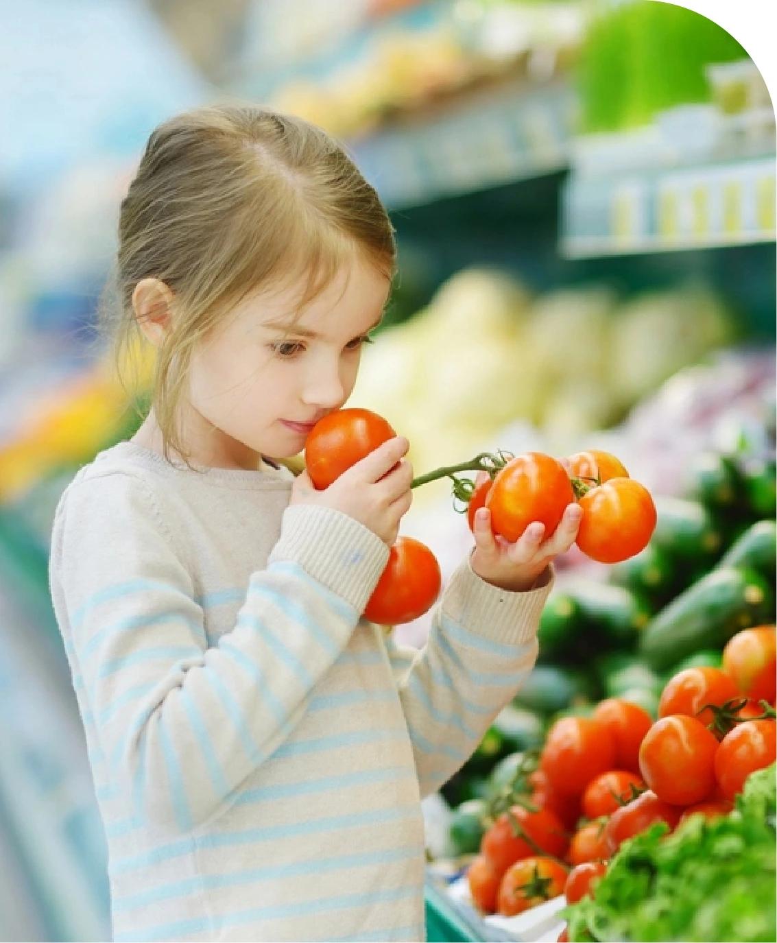 A girl smelling fruits.