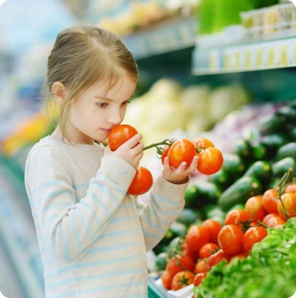 A girl smelling fruits.