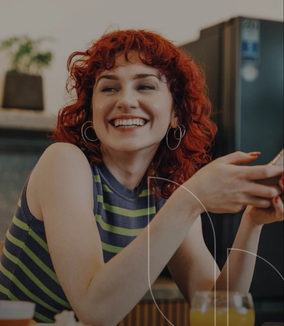 A women laughing by holding a phone